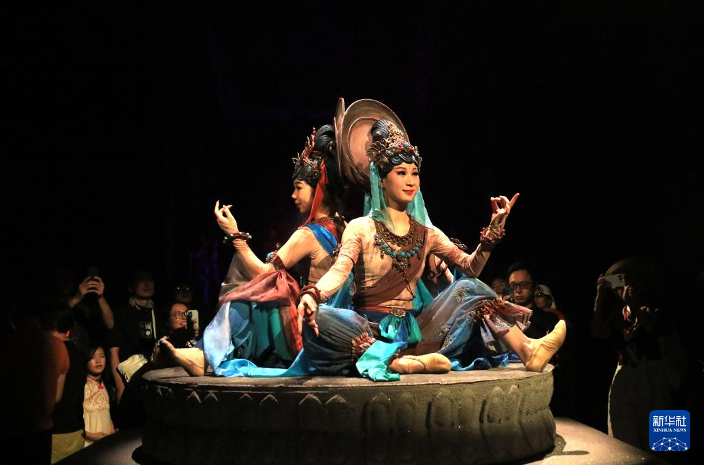 8月5日晚，游客在甘肅省敦煌市觀看大型洞窟式沉浸體驗劇《樂動敦煌》。 新華社發（張曉亮 攝）